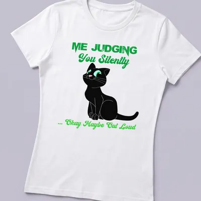 Cartoon black cat with text about judging, in black, green, and white colors — printed on a women's shirt