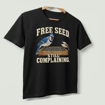 Illustration of a Blue Jay with humorous text about free seeds — printed on a unisex t-shirt (angled view)