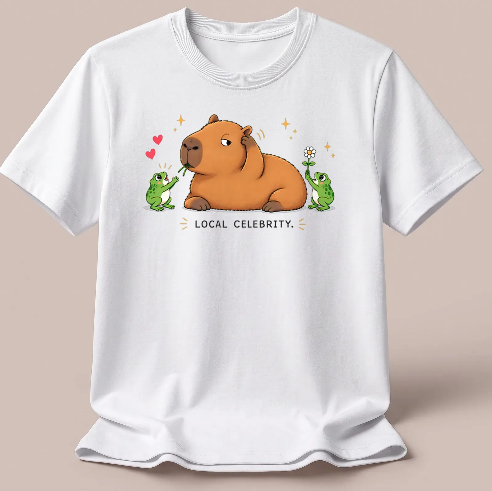 Kawaii style capybara surrounded by frog fans with text 'LOCAL CELEBRITY.' — printed on a unisex t-shirt
