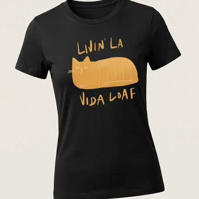 Kawaii illustration of a loafing cat with text 'Livin' La Vida Loaf' in orange and cream. — printed on a women's shirt