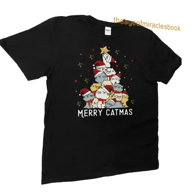 Cartoon cats in Santa hats with Merry Catmas text on a festive shirt. — printed on a unisex t-shirt (angled view)