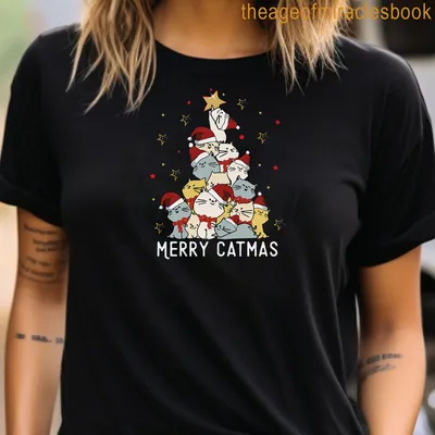 Cartoon cats in Santa hats with Merry Catmas text on a festive shirt. — printed on a women's t-shirt