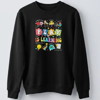 Colorful cartoon design featuring educational icons and the phrase 'Play Is Learning' — printed on a unisex sweatshirt