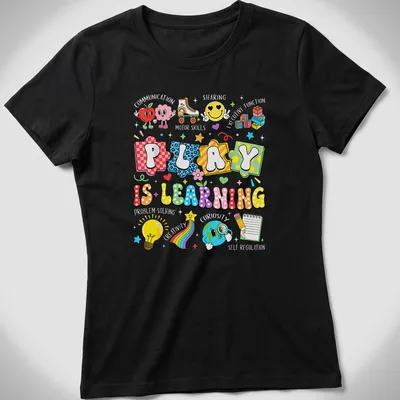 Colorful cartoon design featuring educational icons and the phrase 'Play Is Learning' — printed on a women's shirt