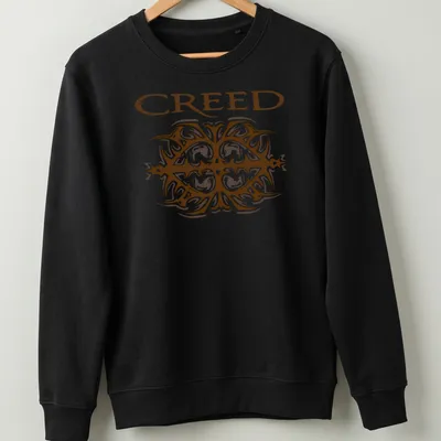 Ornate printed design of the Creed band logo in brown and white — printed on a unisex sweatshirt