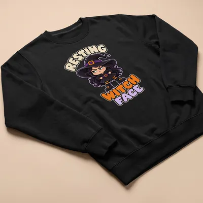 Kawaii grumpy witch illustration with Resting Witch Face text in purple, black, orange, and beige — printed on a unisex sweatshirt