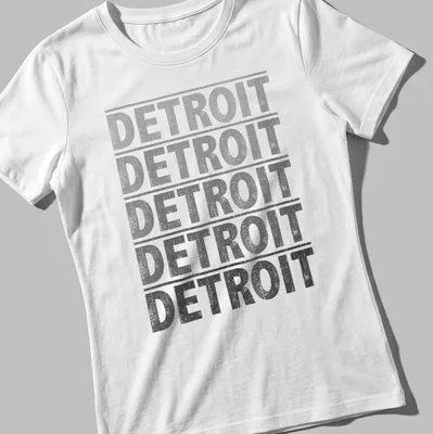 Distressed Detroit text graphic tee in gray, black, and white — printed on a women's shirt