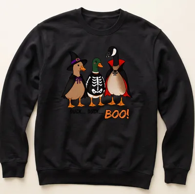 Cartoon ducks in costumes with the text Duck Duck Boo! in vibrant colors. — printed on a unisex sweatshirt