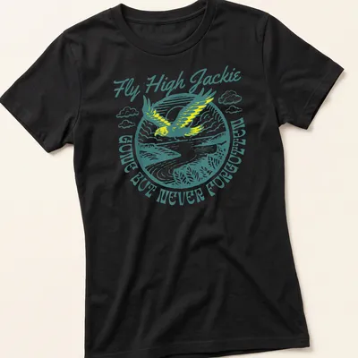Vintage illustration of an eagle with text 'Fly High Jackie GONE BUT NEVER FORGOTTEN' in teal and yellow — printed on a women's shirt