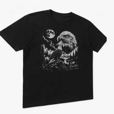 Detailed illustration of an eagle in flight with memorial text below. — printed on a unisex t-shirt (angled view)