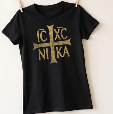 Distressed vintage t-shirt featuring the Eastern Orthodox Christian symbol IC XC NIKA in gold — printed on a women's shirt