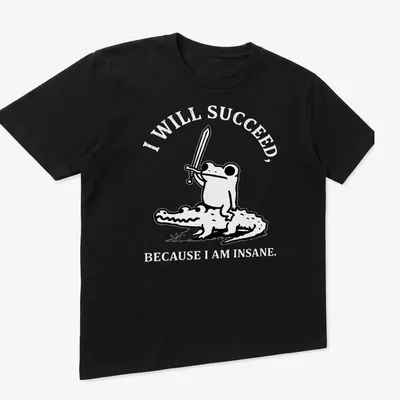 Kawaii line-art shirt depicting a frog riding a crocodile with motivational text — printed on a unisex t-shirt (angled view)