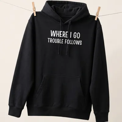 Bold typography on a white shirt reading 'Where I Go Trouble Follows' — printed on a unisex hoodie