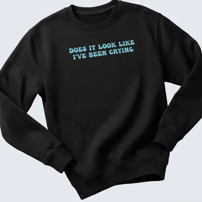 Light blue t-shirt with bold text reading 'Does it look like I've been crying' in a playful font. — printed on a unisex sweatshirt