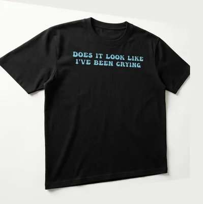 Light blue t-shirt with bold text reading 'Does it look like I've been crying' in a playful font. — printed on a unisex t-shirt (angled view)