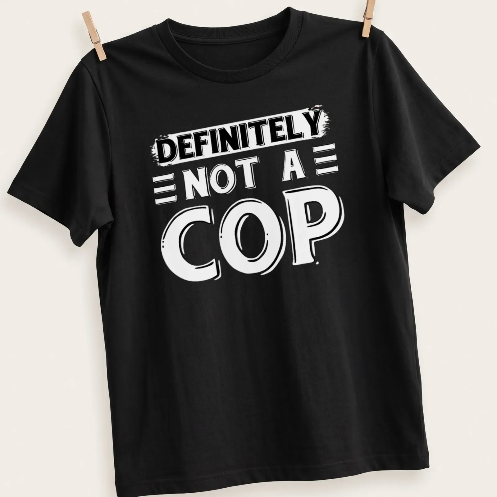 Bold typography shirt stating 'DEFINITELY NOT A COP' in black and white — printed on a unisex t-shirt