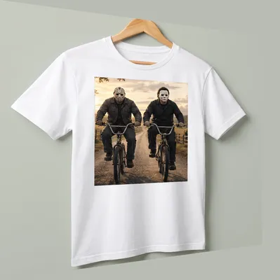 Realistic depiction of Jason Voorhees and Michael Myers riding bikes in dark colors — printed on a unisex t-shirt (angled view)