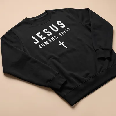 Bold typography t-shirt featuring Jesus and Romans 10:13 in white text — printed on a unisex sweatshirt