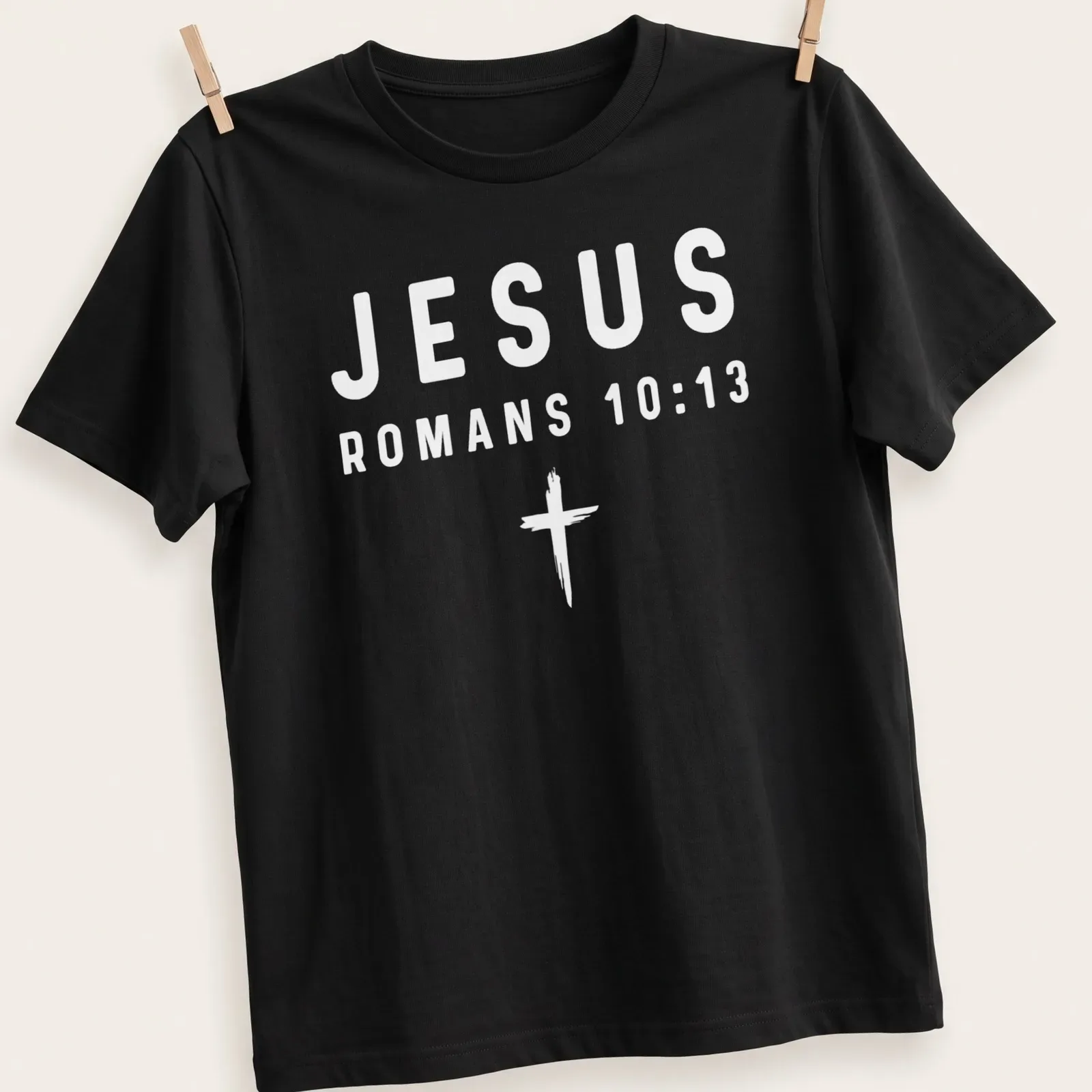 Bold typography t-shirt featuring Jesus and Romans 10:13 in white text — printed on a unisex t-shirt