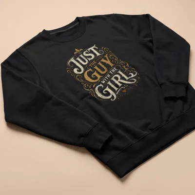 Ornate vintage typography t-shirt with 'Just The Guy With The Girl' printed in gold and cream — printed on a unisex sweatshirt