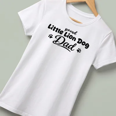 Bold typography t-shirt stating 'proud Little Lion Dog Dad' with playful Little Lion Dog illustration — printed on a women's shirt