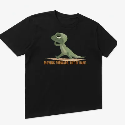 Cartoon lizard graphic with text about moving forward out of habit in green and orange — printed on a unisex t-shirt (angled view)