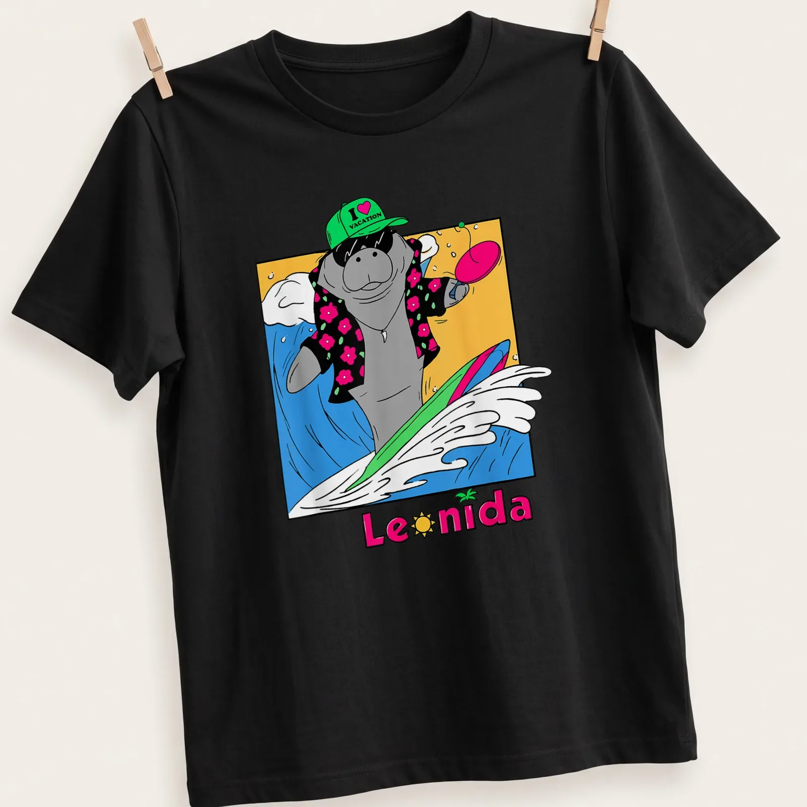 Cartoon manatee surfing with colorful text that reads I love vacation Leonida — printed on a unisex t-shirt