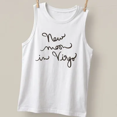Handwritten script design reading 'New moon in Virgo' in black text — printed on a tank top