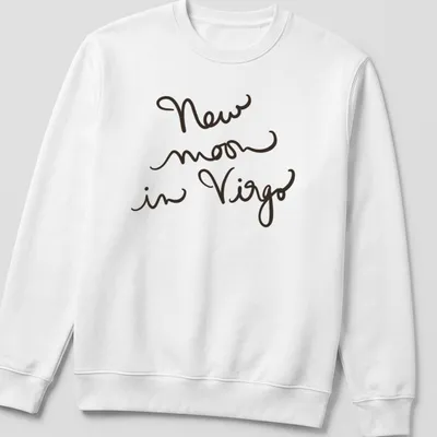 Handwritten script design reading 'New moon in Virgo' in black text — printed on a unisex sweatshirt