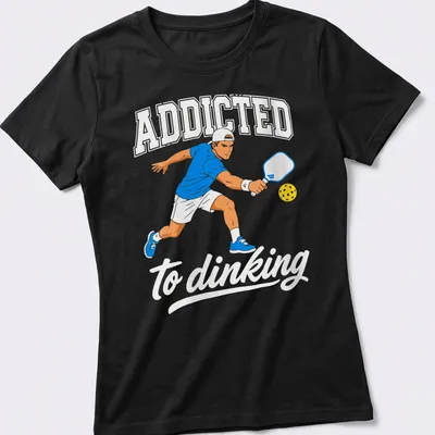Bold printed text 'ADDICTED to dinking' with a Pickleball player design — printed on a women's shirt