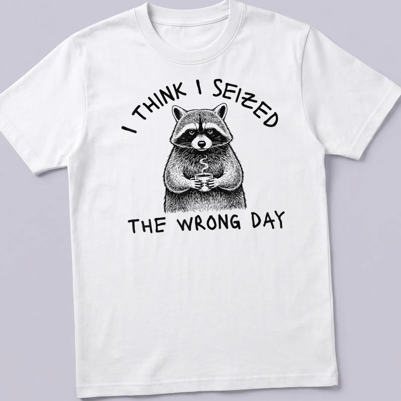 Detailed line-art of a raccoon holding a coffee cup with humorous text about seizing the day — printed on a unisex t-shirt