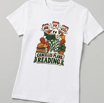 Whimsical ghost reading a book with text 'CANCELLED PLANS. READING.' in playful design — printed on a women's shirt