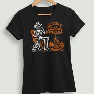 Retro print of a skeleton sitting by a campfire with bold text. — printed on a women's shirt