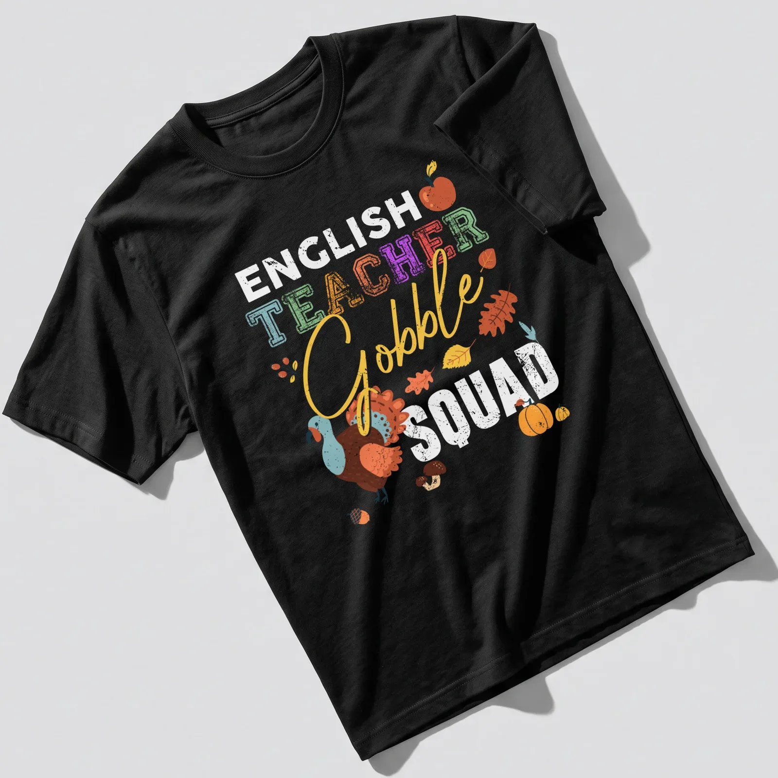 Playful turkey illustration with colorful text 'TEACHER Gobble' for Thanksgiving — printed on a unisex t-shirt