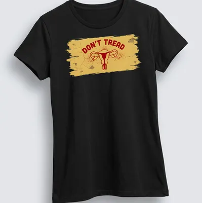 Bold graphic t-shirt featuring uterus and DON'T TREAD text in yellow and red — printed on a women's shirt