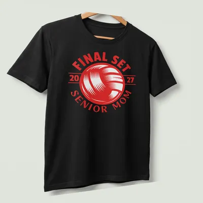 Bold graphic t-shirt celebrating volleyball Senior Mom 2027 with red and white text — printed on a unisex t-shirt (angled view)