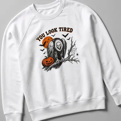 Vintage Halloween vulture illustration with pumpkin and text reading 'YOU LOOK TIRED' — printed on a unisex sweatshirt