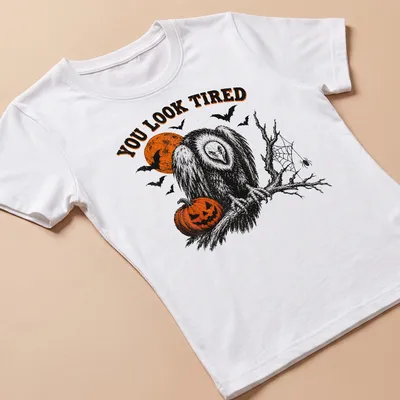 Vintage Halloween vulture illustration with pumpkin and text reading 'YOU LOOK TIRED' — printed on a women's shirt